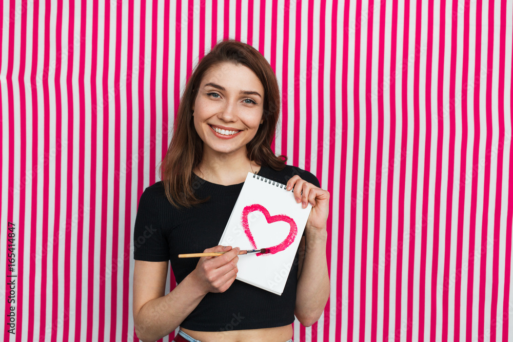 Attractive girl with drawing heart on notebook Attractive girl with drawing heart on notebook