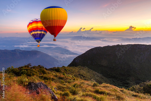 Colorful hot-air balloons flying over the Doi Luang Chiang Dao with sunrise and morning mist at Chiang mai, Thailand.