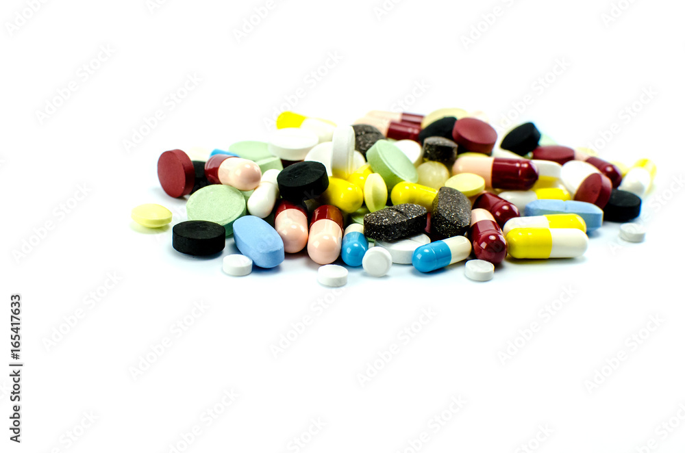 Tablets and capsules with medicine of different colors and sizes on a white background.