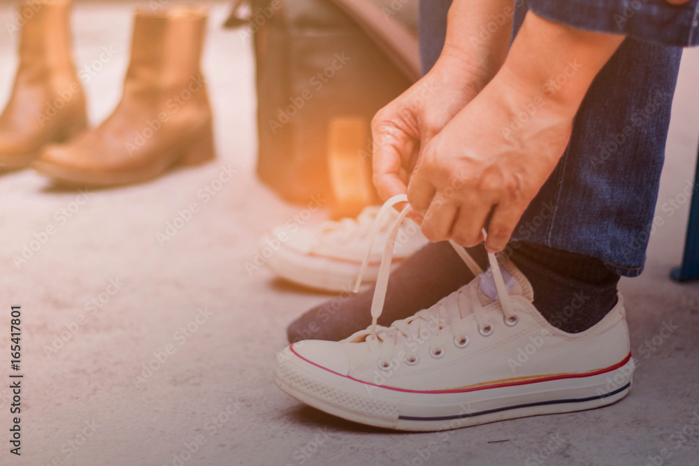 Naklejka premium Hands are laced sneakers.