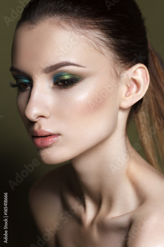 Beautiful young model with fashion make up, perfect skin. Trendy colorful smoky eyes. Green smoky eyes