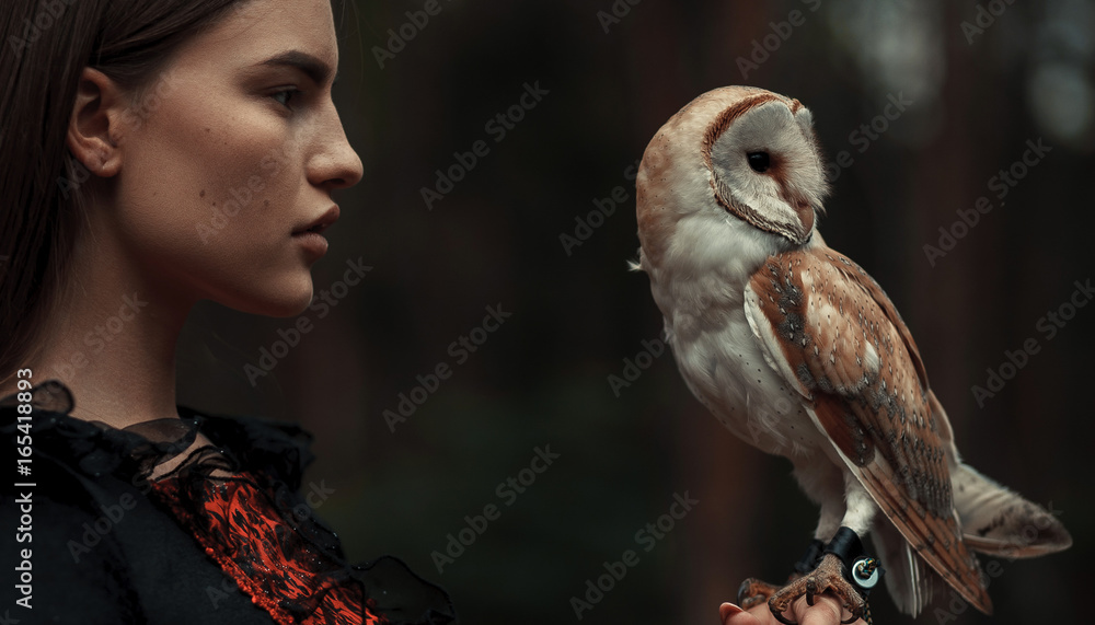 Naklejka premium Portrait of girl with owl in hand. Close-up.