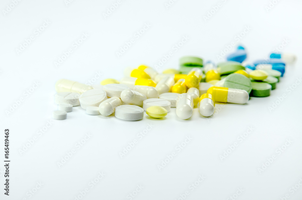White, yellow, green and blue tablets and capsules with medicine. White, yellow, green and blue tablets and capsules with medicine.