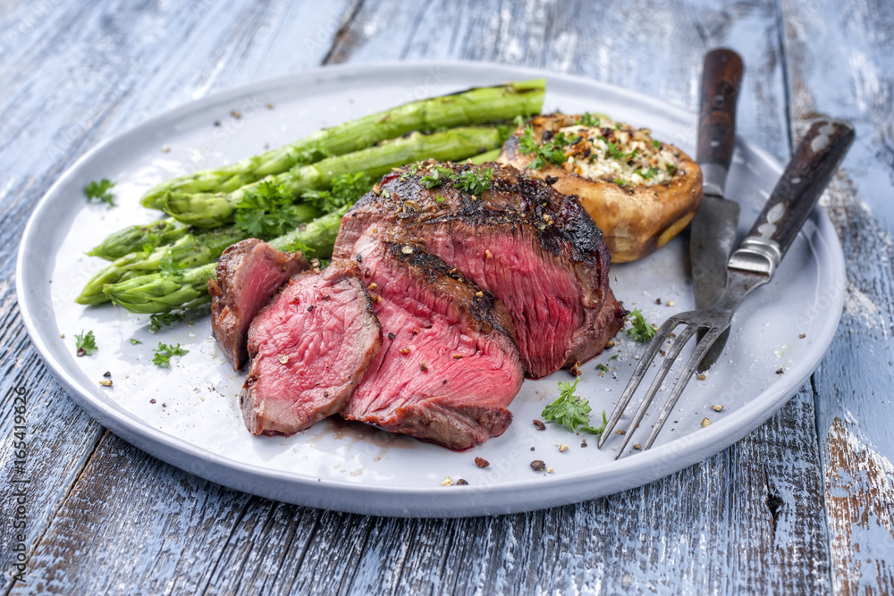 © HLPhoto - Barbecue Wagyu Hüftsteakt mit grünen Spargel und Pilzkappen als close-up auf Teller