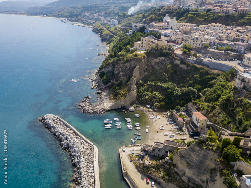 Vista aerea di Pizzo Calabro, Calabria, Italia. Case sulla roccia, porto e molo con barche ormeggiate.