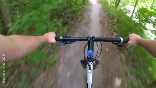 Ride a bicycle in the woods on a dirt road. Action camera go pro.