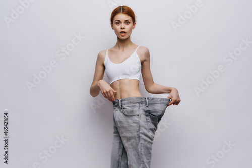 Young beautiful woman on a light background, losing weight, sports, fitness, progress, success