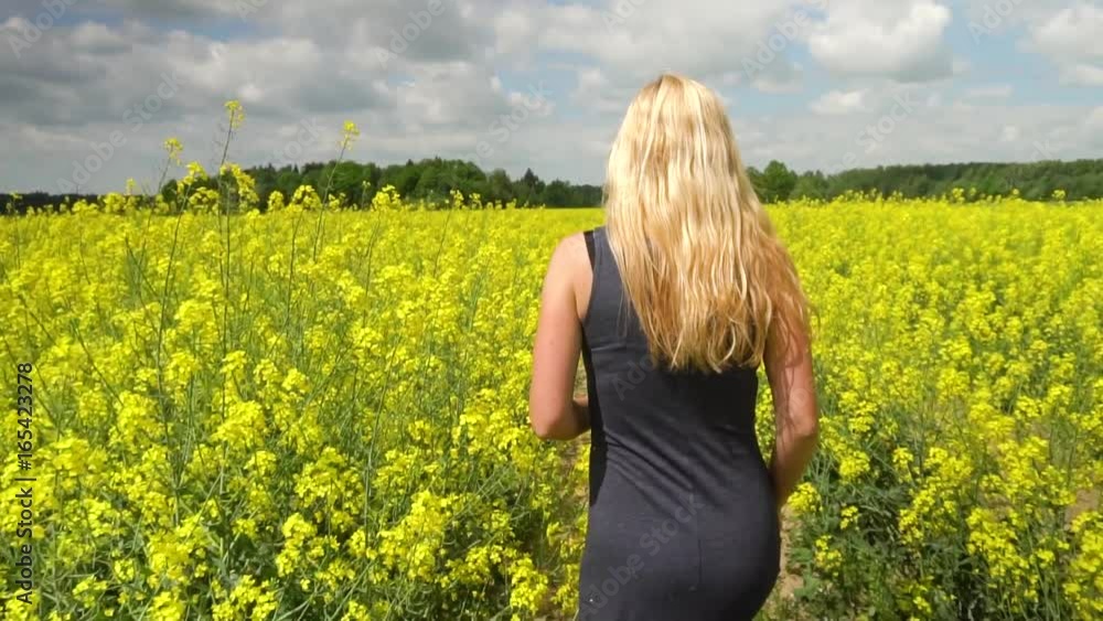 young blonde woman posing in beautiful rapeseed field young blonde woman posing in beautiful rapeseed field