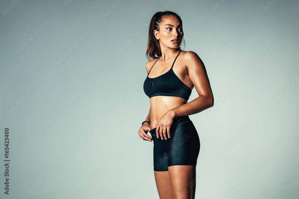 Obraz premium Fitness woman in sportswear standing over grey background