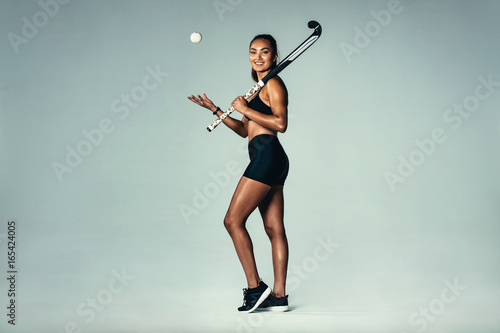 Happy young woman holding hockey stick and ball © Jacob Lund