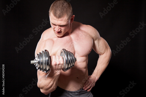 Sport the athlete bodybuilder build muscles dumbbells