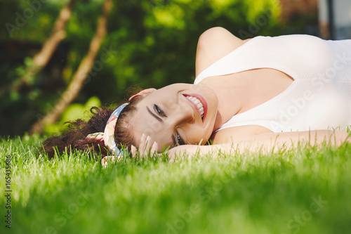 Happy young woman lies on fresh juicy grass