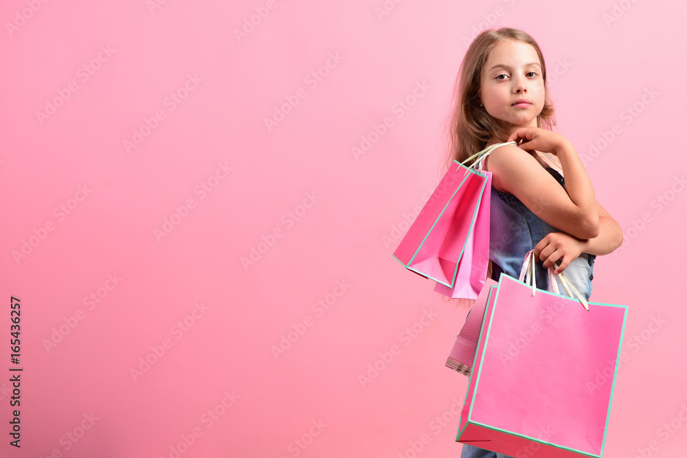 School girl with packages isolated on pink background