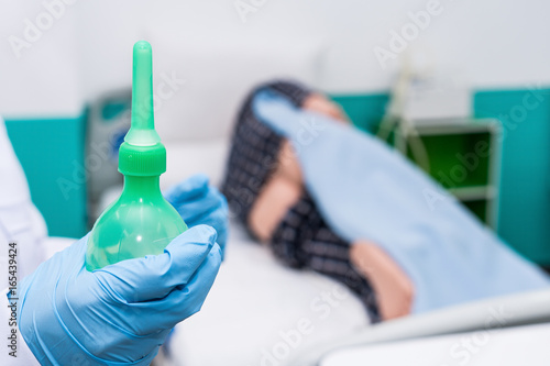 Obraz na plátně Doctor gives her patient for enema to resolve constipation problem