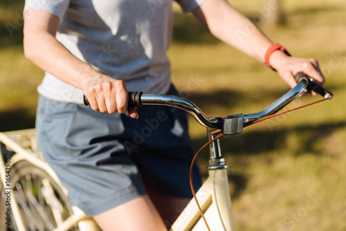 Pleasant woman riding bicycle in the park