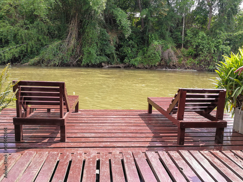 empty wood chairs at riverside with mountain and fog behide in Kanchanaburi., Thailand