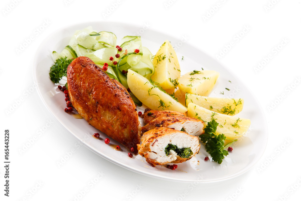 Stuffed chicken fillets and vegetables on white background Stuffed chicken fillets and vegetables on white background