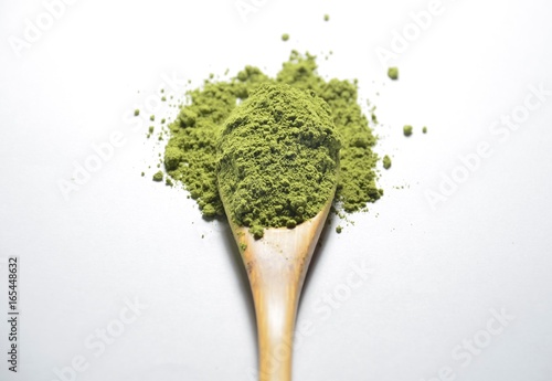 Matcha Green Tea powder full filled in wooden tea spoon isolated on white background