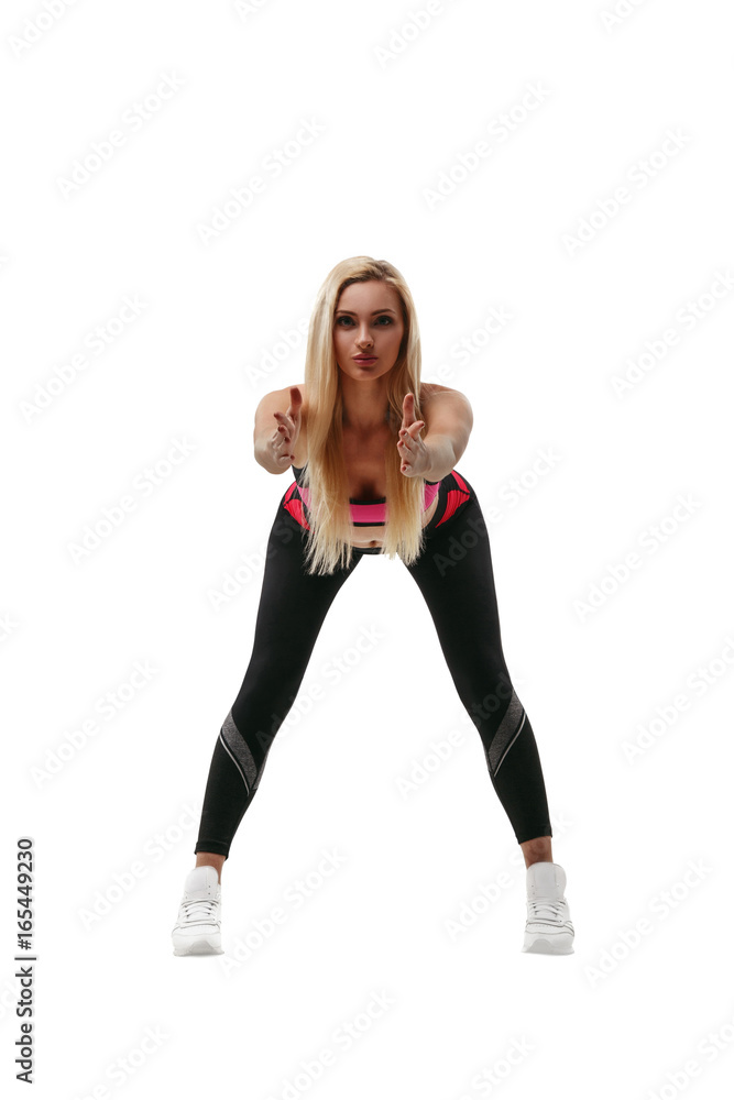 Portrait of a beautiful young blond fitness woman in sportswear doing workout isolated on white background