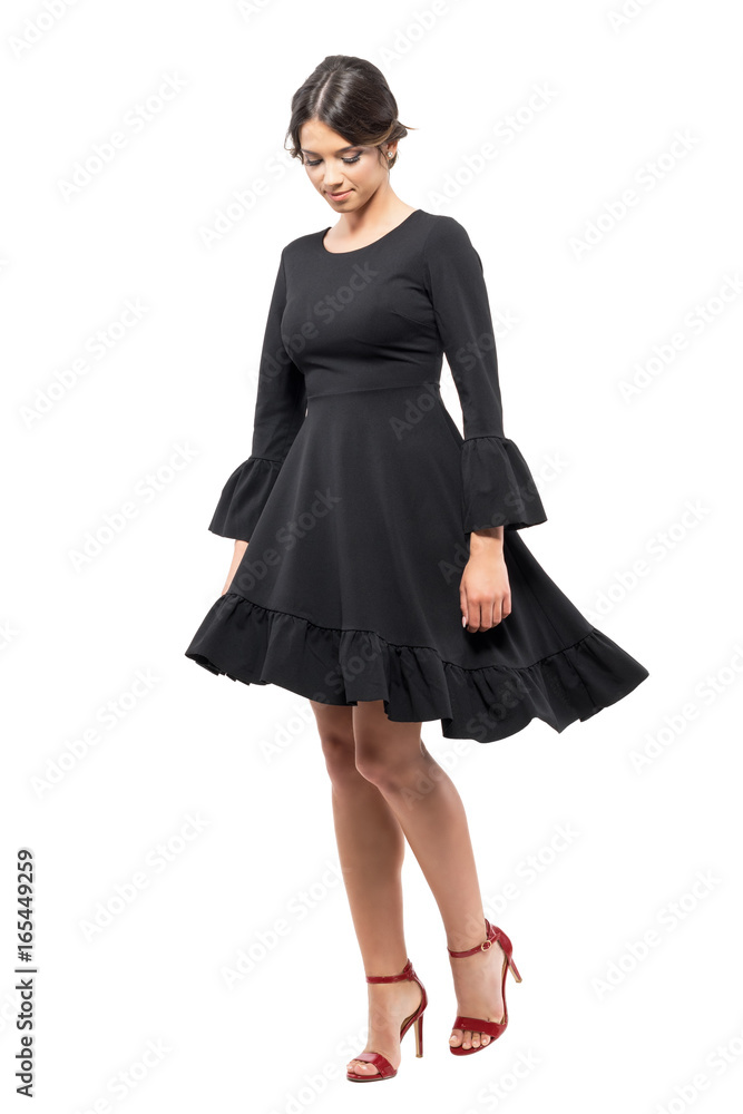 Latin woman dancing with black dress spinning movement looking down. Full body length portrait isolated on white background. Latin woman dancing with black dress spinning movement looking down. Full body length portrait isolated on white background.