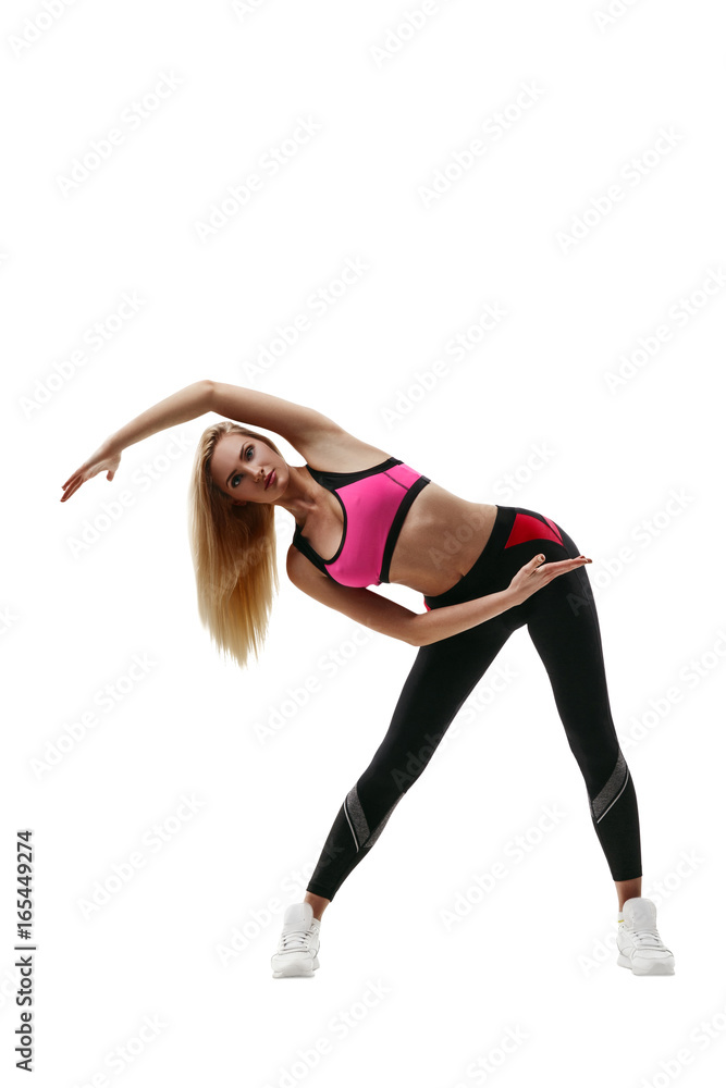 Portrait of a beautiful young blond fitness woman in sportswear doing workout stretching isolated on white background