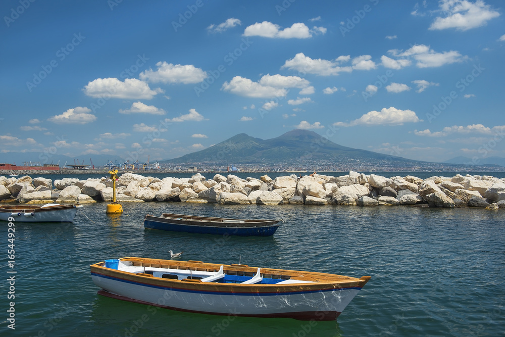 fishing boats in the port of Naples and view of Mount Vesuvius