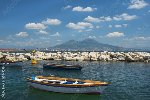 fishing boats in the port of Naples and view of Mount Vesuvius