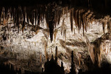 Postojna cave, Slovenia. Formations inside cave with stalactites and stalagmites. People travel by entertainment train in Postojna Cave. it is one of top Slovenian tourism sites.