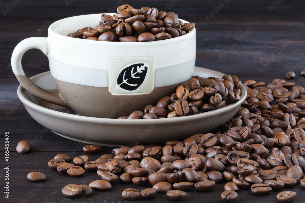Close up of cup of espresso with fresh beans on a wooden table Close up of cup of espresso with fresh beans on a wooden table