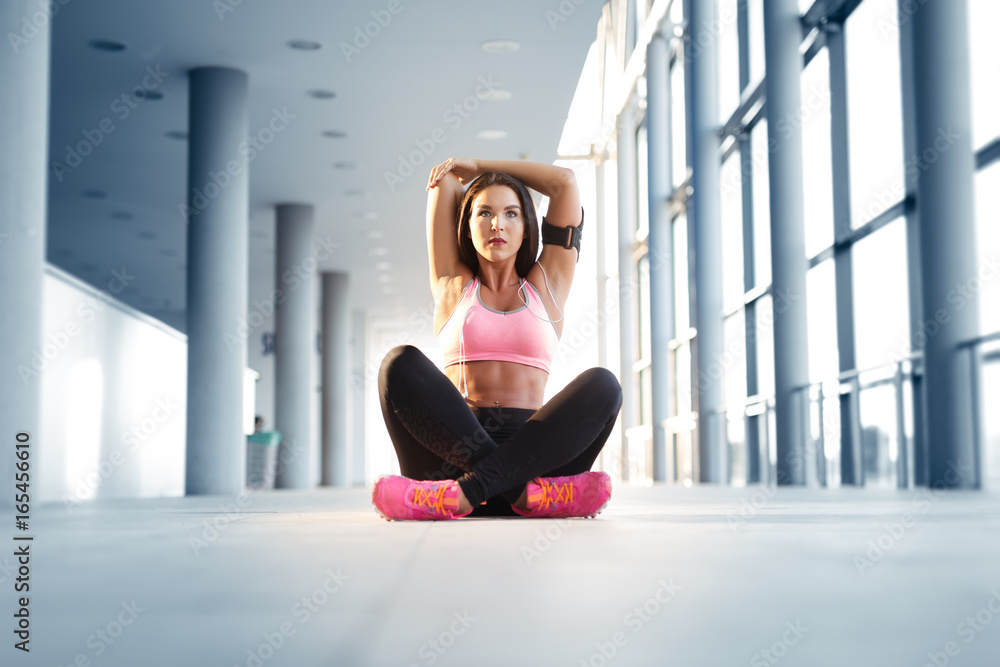 Fototapeta premium Young athletic woman stretching before running exercise