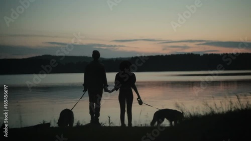 Couple with two dogs on beach