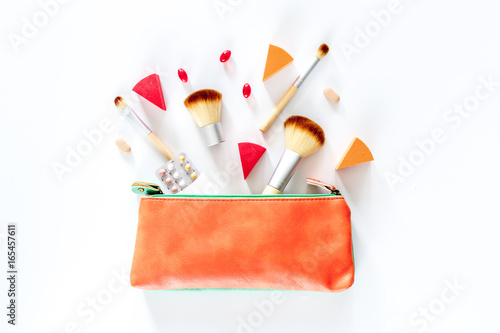 Beauty bag with cosmetics, contraceptives and pills on white table background top view copyspace photo