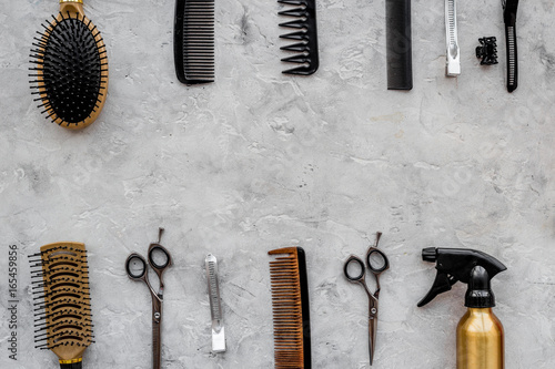 Hairdresser workplace. Combs and sciccors on grey table background top view copyspace