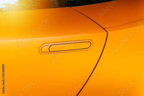 Car door handle of an orange modern car