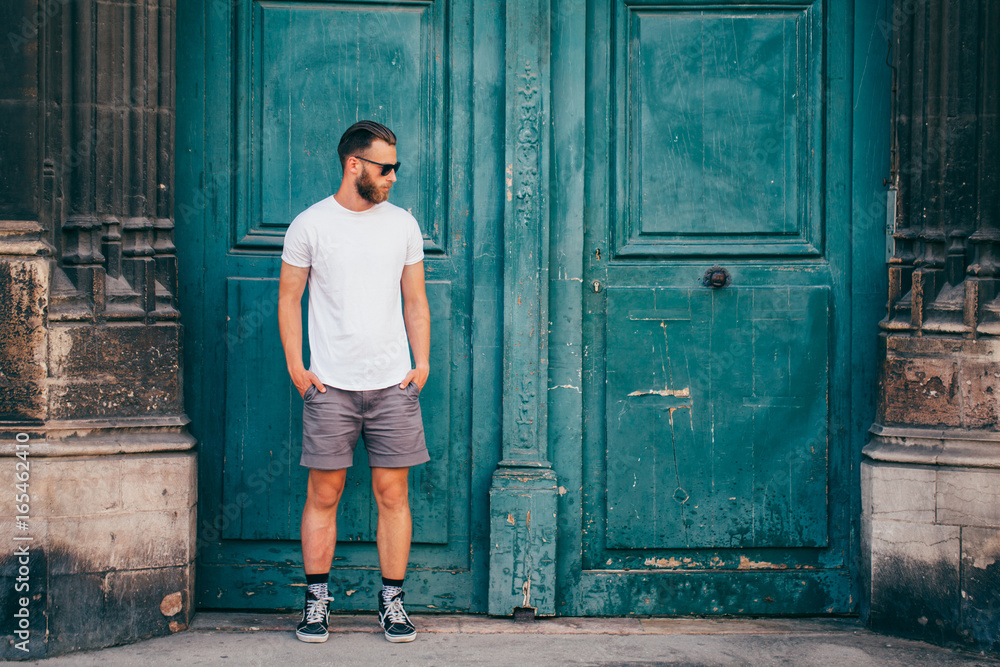 Hipster handsome male model with beard wearing white blank t-shirt with space for your logo or design in casual urban style Hipster handsome male model with beard wearing white blank t-shirt with space for your logo or design in casual urban style
