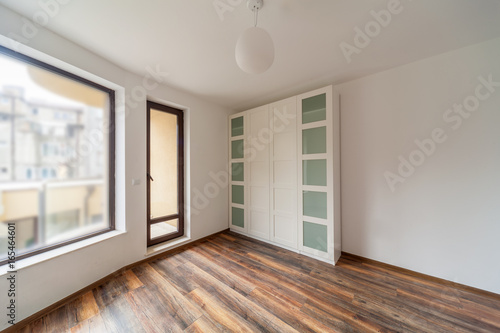 Beautiful modern house  empty room with white wardrobe  closet   wooden floor