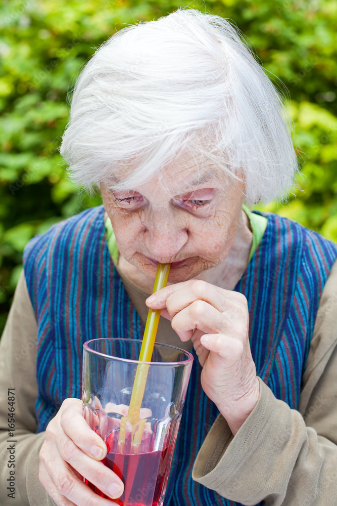 Old woman with alzheimer disease drinking raspberry juice Old woman with alzheimer disease drinking raspberry juice