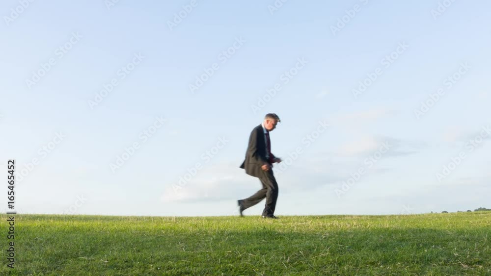 Happy carefree middle aged Caucasian businessman playing air guitar on a hill messing about daydreaming being a rock musician Happy carefree middle aged Caucasian businessman playing air guitar on a hill messing about daydreaming being a rock musician