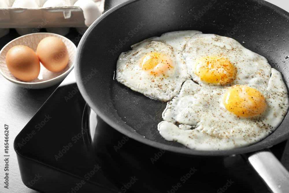 Delicious over easy eggs in pan on stove Delicious over easy eggs in pan on stove