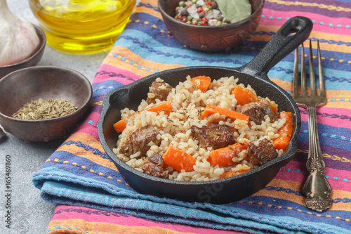 Devzira pilaf with lamb, onions, carrots and spices (cumin, coriander, pepper). Traditional dishes of Uzbek cuisine. Selective focus