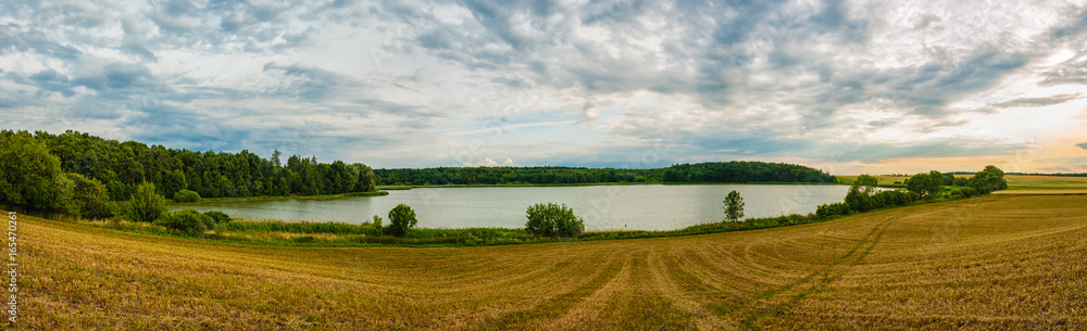 Beautiful place with nice clean lake, forest and field. Sunset on summer, panoramatic view.