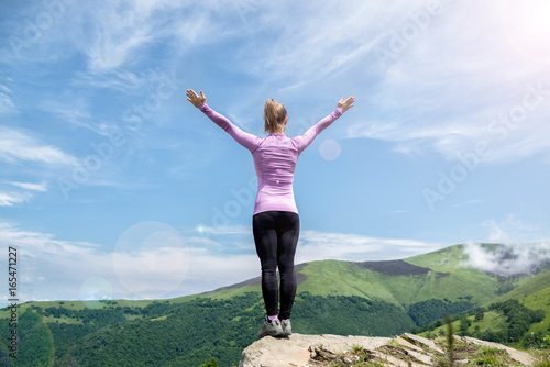 Young woman on the top of mountain