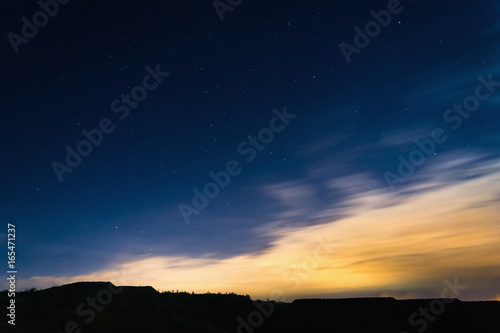 Night sky with stars next to horizon silhouette at summer