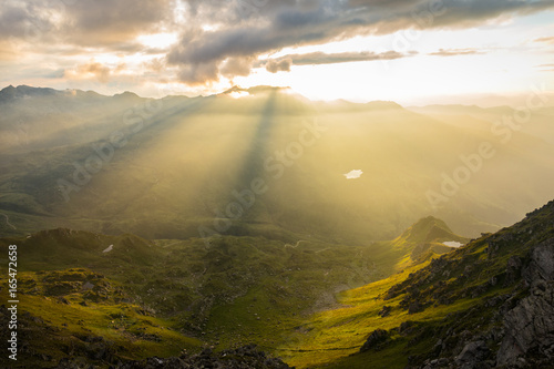 Ausblick vom Gipfel ins Tal mit Sonnenstrahlen