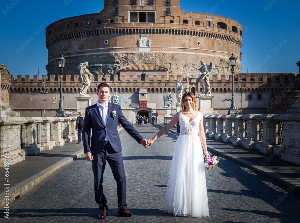 Bride and groom wedding poses in front of Castel Sant'Angelo, Rome, Italy
