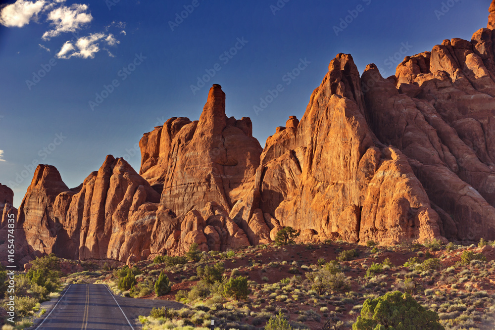 Open road beckons with adventure through sandstone pinnacles and peaks of Arches National Park