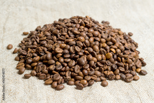 Fototapeta Naklejka Na Ścianę i Meble -  Spilled grains of fragrant coffee close-up.