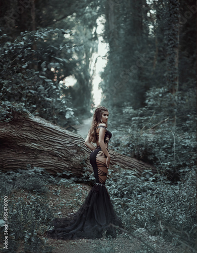 Fototapeta Naklejka Na Ścianę i Meble -  The evil queen is walking in the woods. Wild Princess , vampire, creative color, dark boho