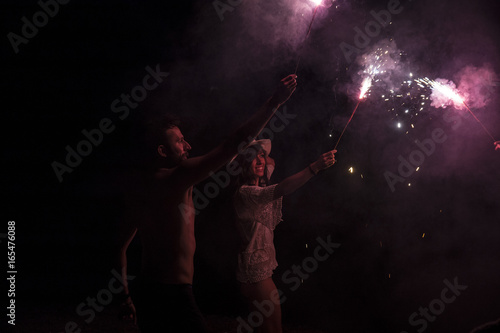 Friends playing with sparkles at the night