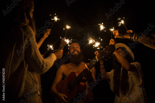 Friends playing with sparkles at the night